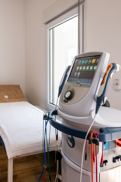 Medicinski aparat za elektroterapiju sa ekranom i elektrodama, korišćen u fizikalnoj terapiji starijih pacijenata za smanjenje bola i poboljšanje pokretljivosti