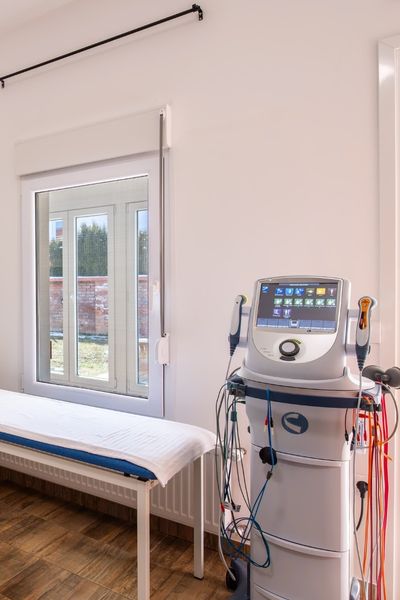 Aparat za elektroterapiju sa kablovima i elektrodama, namenjen rehabilitaciji starijih osoba za jačanje mišića i ublažavanje bola